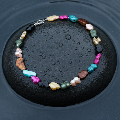 Handgeknoopte zoetwater parelketting met gekleurde parels liggend op steen in water | Pearl Peanut Color