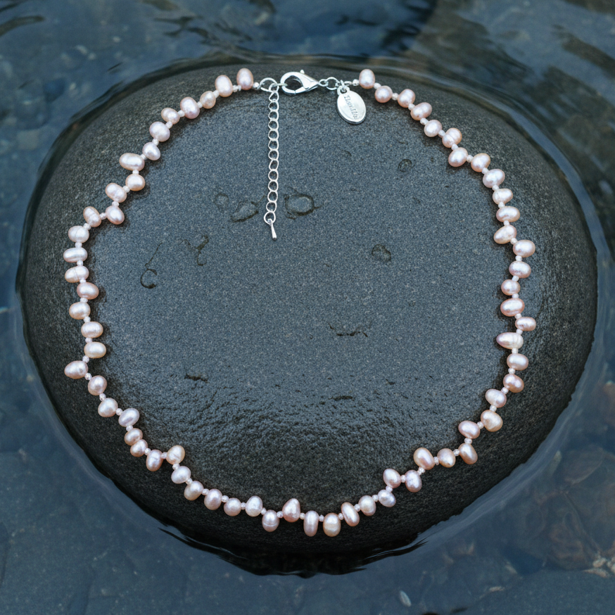 Zoetwater parelketting met zalm roze parels en sterling zilver (925) liggend op steen in water | Rozi
