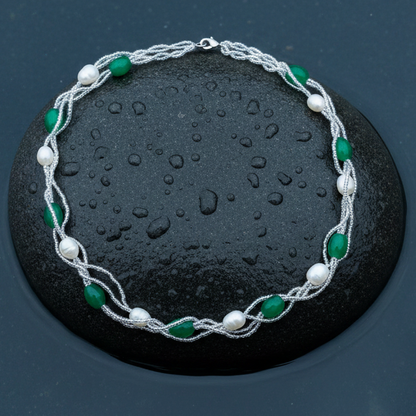 Witte zoetwater parelketting met groene kralen in 4 rijen liggend op steen in water | Twine Pearl Green Graass