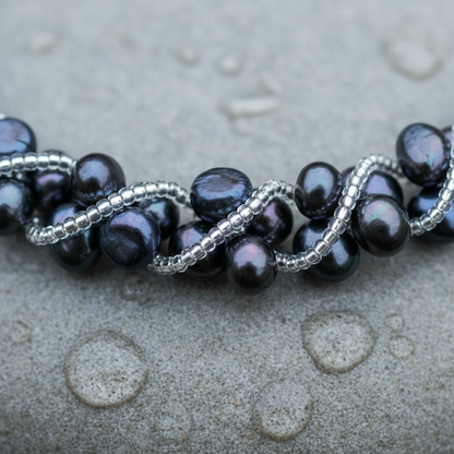 Zoetwater parelketting met blauw zwarte parels iggend op steen in water close up | Veronica