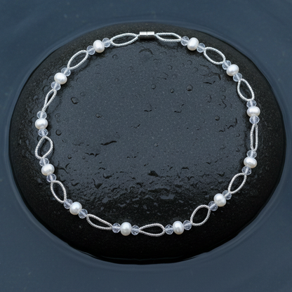Zoetwater parelketting met witte parels en glaskristallen en magneetslot liggend op steen in water| Wicio
