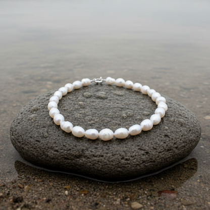 Handgeknoopte witte zoetwater parelketting liggend op natte steen | Wola Two