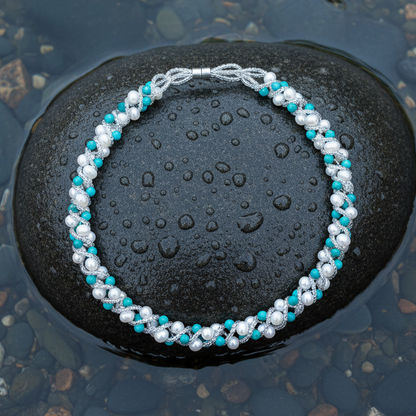 Witte zoetwater parelketting met turkoois en magneetslot liggend op steen in water | Tonica