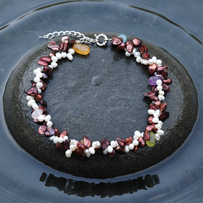 Zoetwater parelketting met witte en rood bruine parels en glaskristallen in 2 rijen liggend op steen in water | Monique