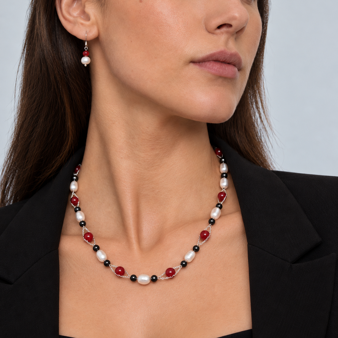 Zoetwater parelketting met magneetslot, witte parels en rode en zwarte kralen op model met zwart colbert | Santa