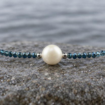 Zoetwaterparel ketting met witte parel, blauwe glas kristallen en magneetslot liggend op steen in water close up | Celeste
