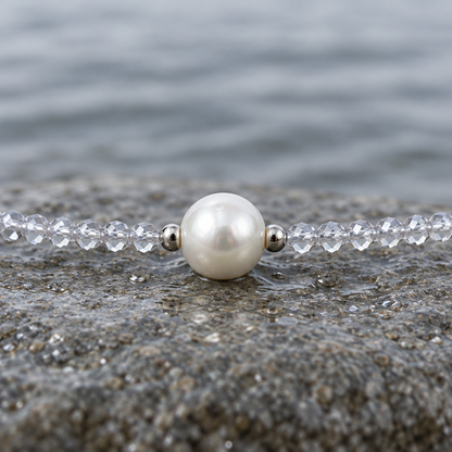 Zoetwaterparel ketting met witte parel, helder transparante glas kristallen en magneetslot liggend op steen close up | Caire