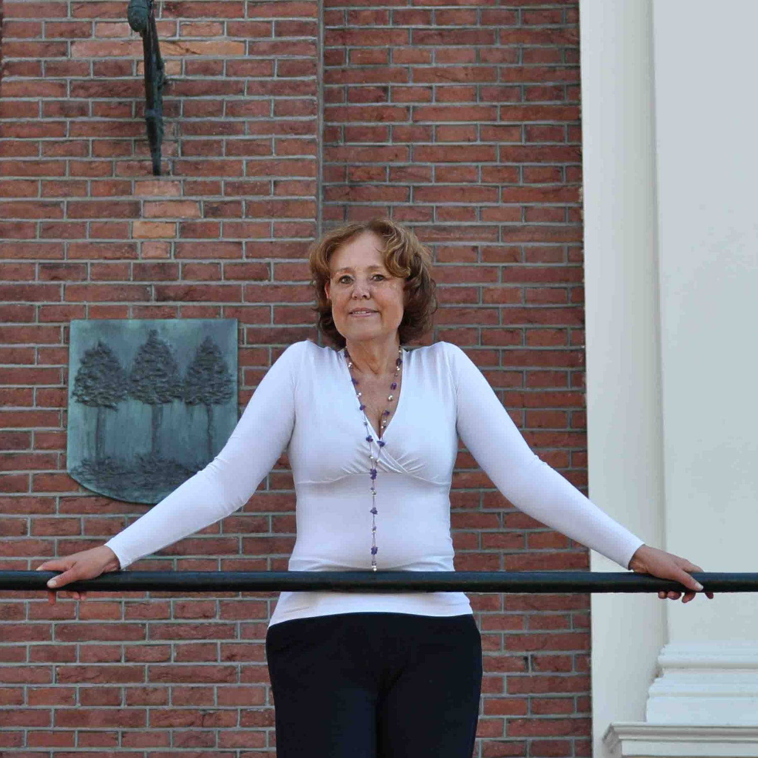 Lange zoetwater parelketting met witte, grijze en zalm kleurige parels en paarse edelsteen amethist op model tegen reling | Sweet Purple
