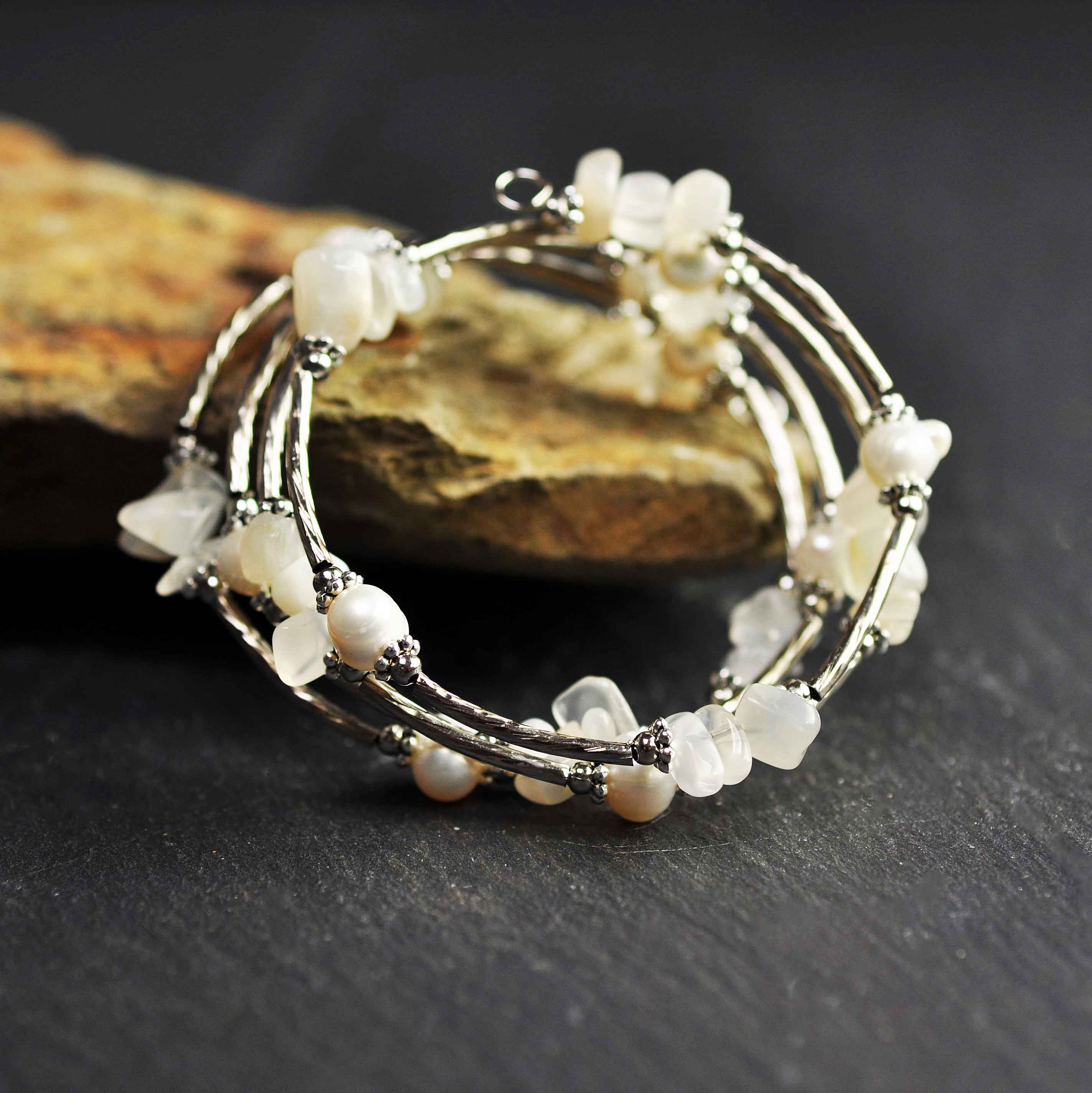 Wit zoetwater parel wikkelarmband met edelsteen maansteen en zilver liggend tegen oranje steen | Wrap Pearl Moonstone