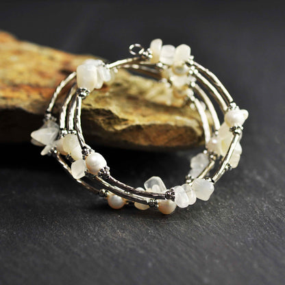Wit zoetwater parel wikkelarmband met edelsteen maansteen en zilver liggend tegen oranje steen | Wrap Pearl Moonstone