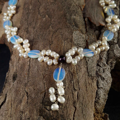 Detail van zoetwater parelketting met witte parels en blauwe edelsteen opaal liggend op hout | Sopal
