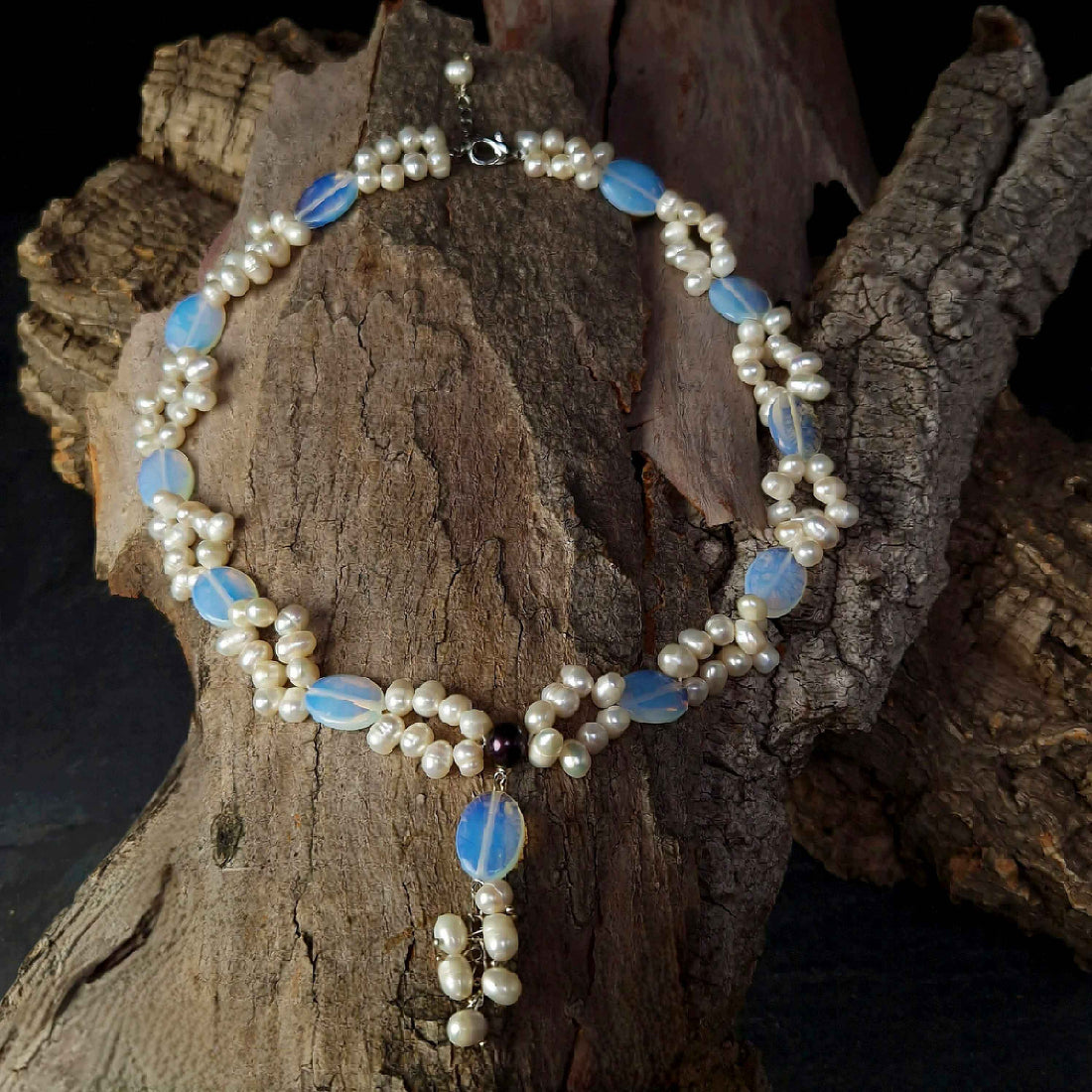 Zoetwater parelketting met witte parels en blauwe edelsteen opaal liggend op hout | Sopal