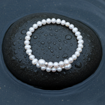 Zoetwater parel wikkel armband met witte parels en sterling zilver (925) liggend op steen in water | Angelica