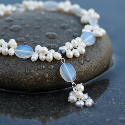 Zoetwater parelketting met witte parels en blauwe edelsteen opaal liggend op natte steen close up | Sopal