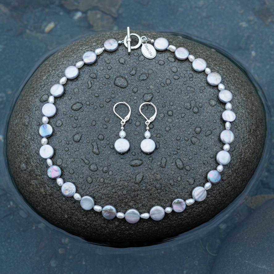 Zoetwater parel set bestaat uit een parelketting en parel oorbellen met witte parels, grijs parelmoer en zilver edelstaal liggend op steen in water | set Pearl Grey Shell R