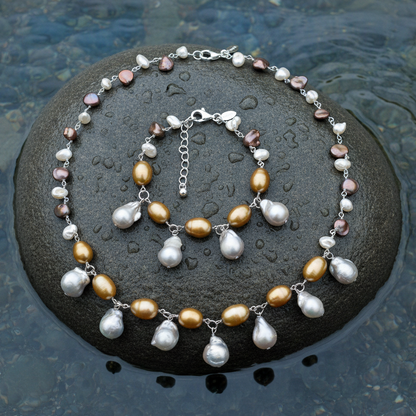 Zoetwater parel set bestaande uit een parelketting en parel armband met grijze, oker en bruine parels liggend op steen in water | set Daisy