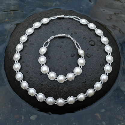Zoetwater parel set bestaande uit parelketting en parel armband met witte parels en magneetslot liggend op steen in water | set Pearl O
