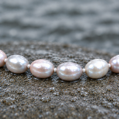 Close-up met gladde parels en kleine witte draadknoopjes tussen de parels