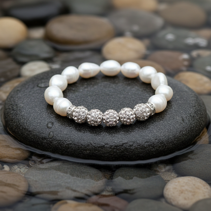 Five Bling Pearl armband close-up op grijze natte steen bij oever