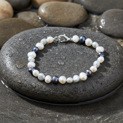 Grey Black White Pearl zoetwater parel armband close-up op grijze natte steen bij oever