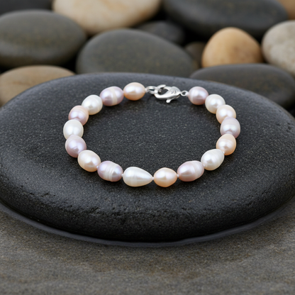 Hermosa parel armband close-up op grijze natte steen bij oever