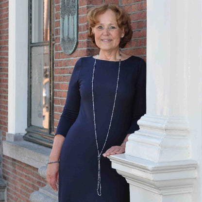 Lange zoetwater parelketting met blauw zwarte parels op model tegen muur | Black Pearl Sweater
