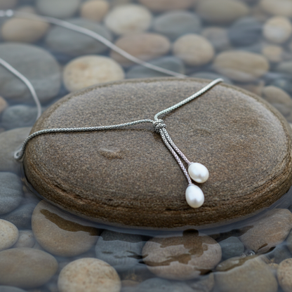 Milou parelketting op realistische steen bij oever