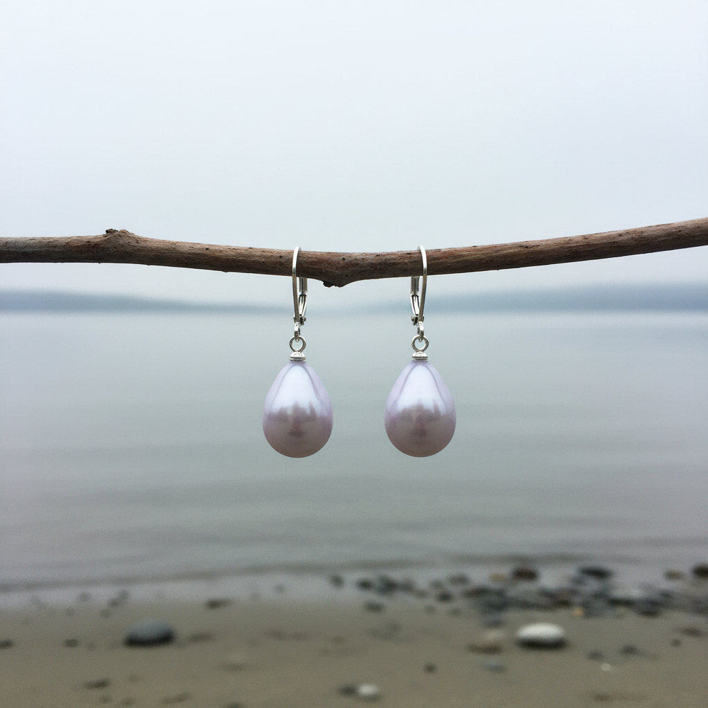 Mother of pearl oorbellen aan horizontaal takje bij waterrand