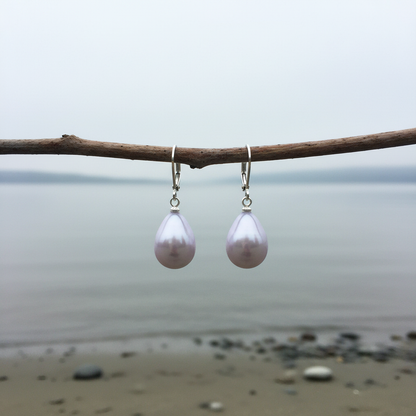 Mother of pearl oorbellen aan horizontaal takje bij waterrand