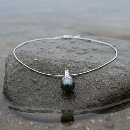 Mother of pearl parelketting met zwart groene parel en stras steentjes liggend op steen vooraanzicht | Blizanie