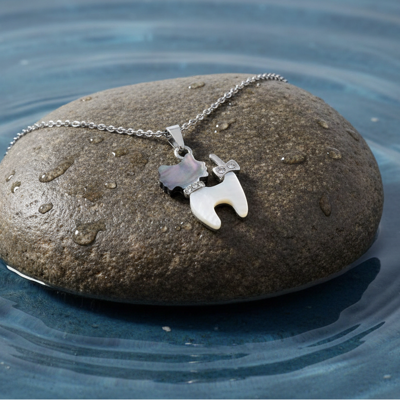 Parelmoeren ketting met parelmoeren hanger met stras steentjes in de vorm van een kat met zilver edelstaal liggend op steen | Shell Cat