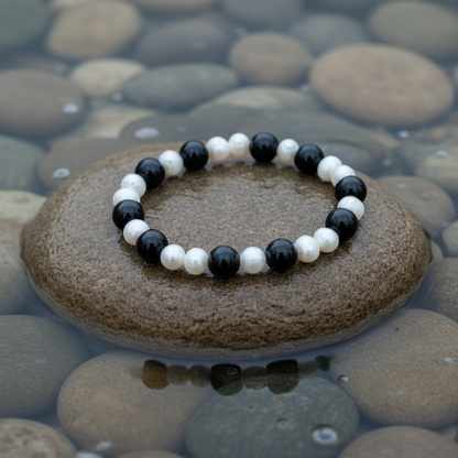 Pearl Black Agate armband close-up op steen bij oever