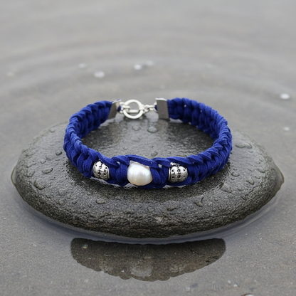 Pearl Blue Suède armband extreme close-up op grijze natte steen