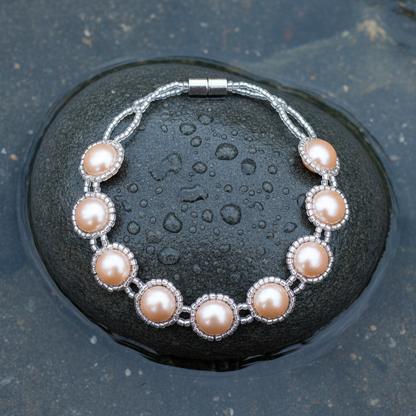 Perzik roze button parels in zilverkleurige glaskralen zetting armband op natte grijze steen