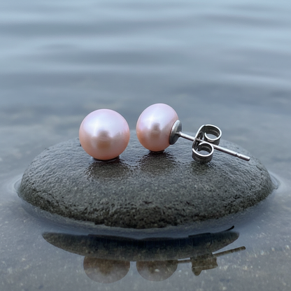 Roze zoetwater parel oorbellen met zilver edelstaal, parel oorknopje liggend op natte steen in water | Pearl Rose 10 mm