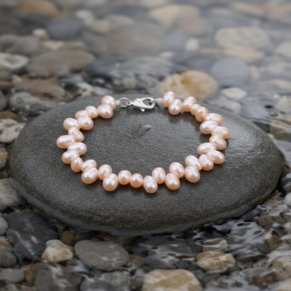 Zamia parel armband close-up op grijze natte steen bij oever