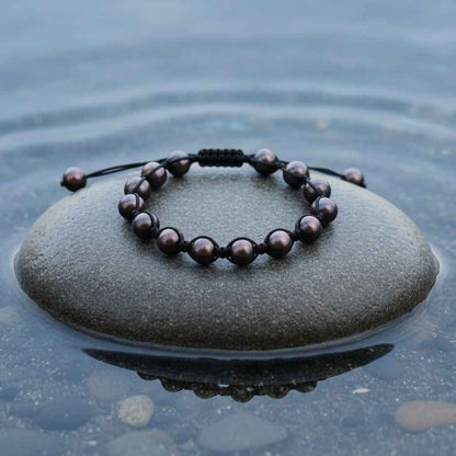 Zoetwater parel armband Sambala Brown Pearl - bovenaanzicht op steen in water