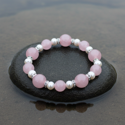 Wit zoetwater parel armband met roze edelstenen rozenkwart en stras steentjes liggend op steen, elastisch | Bling Paerl W Rose Quartz