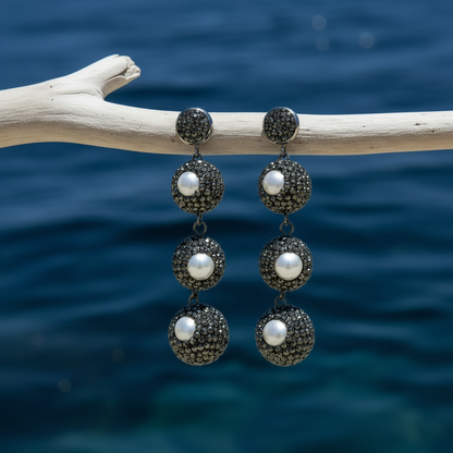 Zoetwater parel oorbellen Bright Pearl Balls aan tak met donkerblauw water