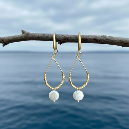 Zoetwater parel oorbellen Milany Gold aan takje met blauw water