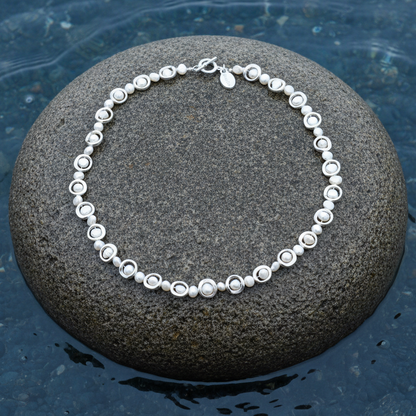 Zoetwater parelketting Pearl Geometric op steen blauwe waterrand bewolkte dag