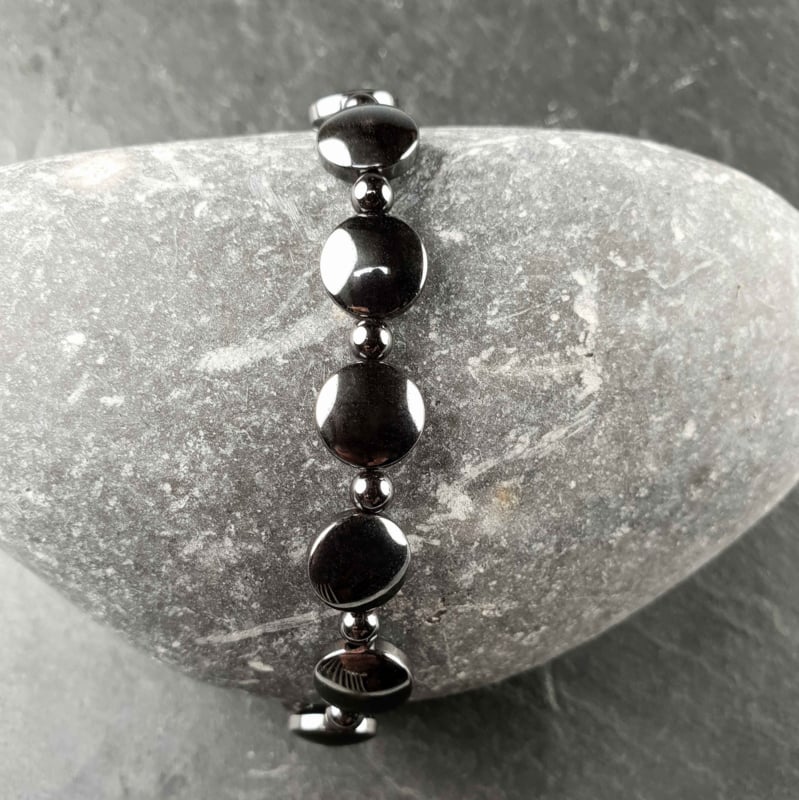 Zwart edelstenen armband met hematiet, elastisch, hoogglans, met achtergrond grijze steen