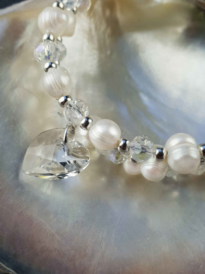 Detail van wit zoetwater parel wikkel armband met kristallen hartje liggend in schelp | Wrap Pearl Crystal Heart