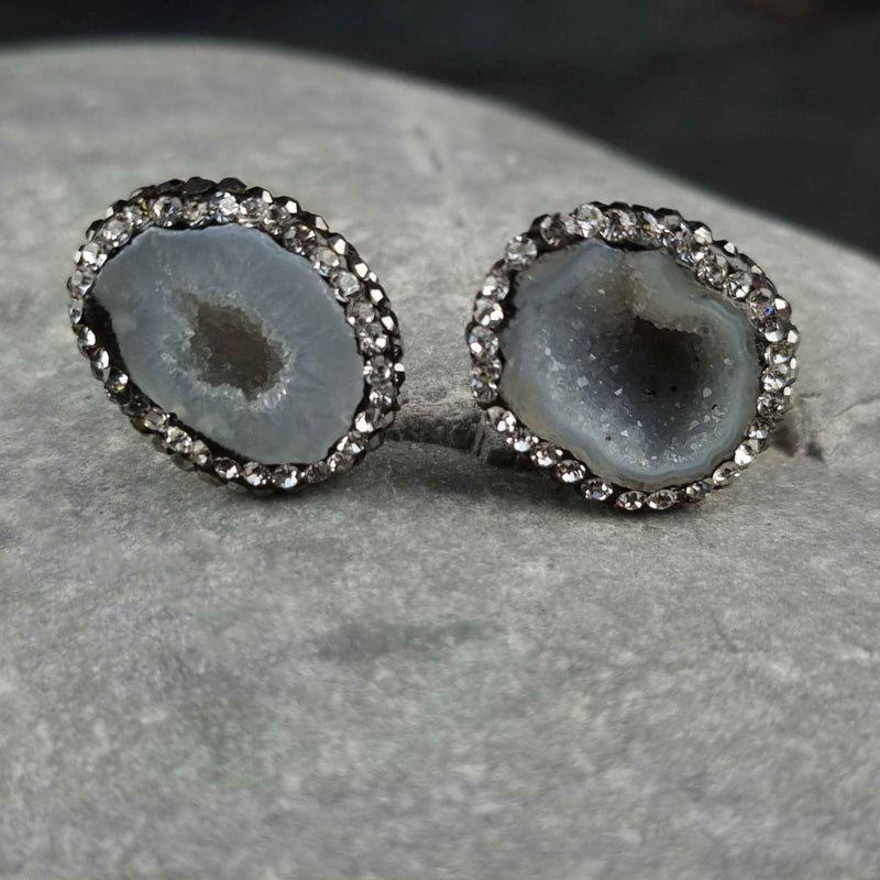 Licht grijze edelstenen oorknoppen met ijskwarts en stras steentjes liggend op kei | Bright Natural Ice Quartz