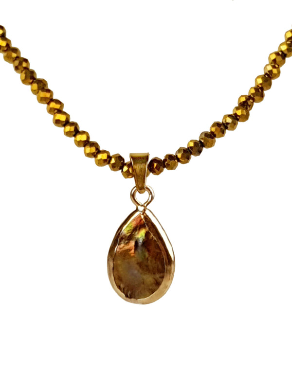 Detail van bruine parelketting met edelstaal en gouden kristallen
