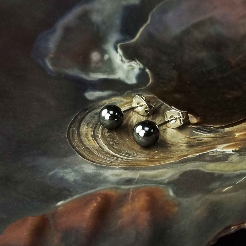 Zwarte edelstenen oorbellen met hematiet stenen liggend in schelp, zwarte hematiet oorknopjes 6 mm liggend in schelp