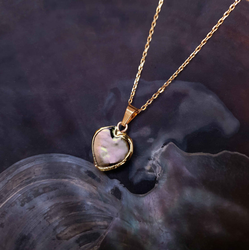 Detail van zoetwater parelketting met bruine parel hanger in hart vorm en goud edelstaal liggend in schelp | Golden Heart Brown Pearl