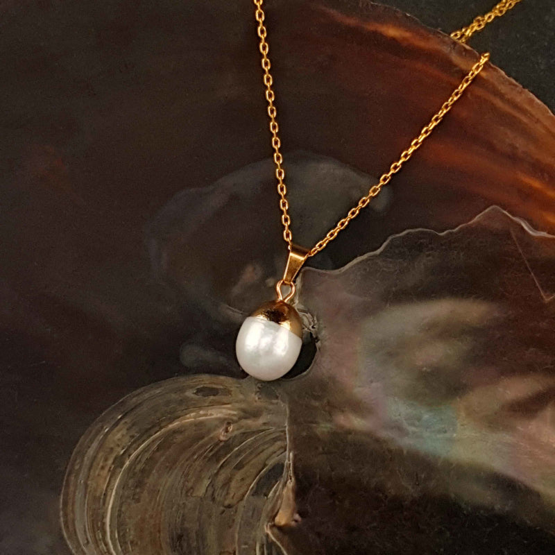 Detail van zoetwater parelketting met witte parel hanger en goud edelstaal liggend in schelp | Gold Dip White Pearl