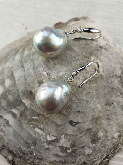 Grijze zoetwater parel oorbellen met sterling zilveren oorbelhaakjes en stras steentje liggend op schelp | Bling Kasumi Grey Pearl