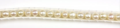 Detail van wit zoetwater parel armband geregen tussen 2 koordjes | Witney